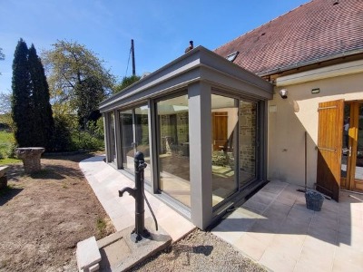 Réalisation d'une maçonnerie de véranda avec une grande ouverture entre les deux pièces de 4 mètres de long une terrasse sur plot